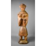 A large carved African figure of a woman, possibly Tswana, with hands raised, with carved