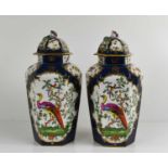 A pair of 19th century hexagonal vases and covers, decorated with birds and insects on a cobalt blue