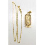 An Egyptian gold pendant, with central lozenge set with hieroglyphs, with filagree border, unmarked,