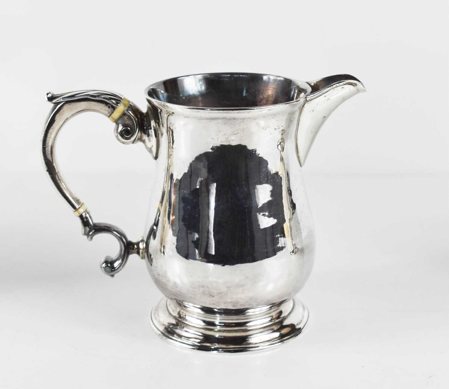 An early George III silver jug, of baluster form, the auricula handle with curled acanthus scroll