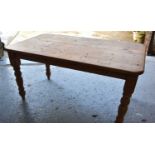 A pine dining table with rectangular top and turned legs, 77cm by 148cm by 84cm.