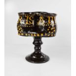 A terracotta treacle glazed puzzle cup, with slip ware inscription 'Here is a Heath to you', 22cm
