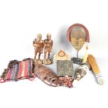 A group of African tribal items to include face masks, hardwood carved figures, wooden ink block and