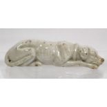 18th century small white glazed porcelain figure of a recumbent dog, 11.5cm long.