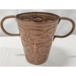 Arts and Crafts copper loving cup of tapered form, with repousse stylised floral decoration and twin
