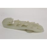 Large Chinese Qing dynasty pale celadon jade belt hook with dragon head terminal, surmounted by a