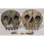 Two antique naïve carved treen Memento Mori skull plaques with traces of painted decoration, each