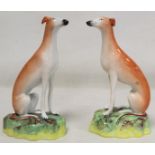 Pair of Staffordshire Pottery greyhounds, each seated on naturalistic domed plinth base, each 21cm