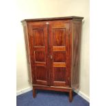 19th century mahogany corner cupboard with two panelled doors enclosing a shelved interior, on a