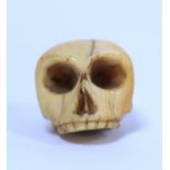 19th century carved ivory Momento Mori skull, approx. 2.5cm long.  NB: Bidders are responsible for