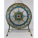 Late 19th/early 20th century firescreen, the circular leaded stained glass panel with flowerhead