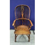 19th century ash and elm Windsor armchair, with a high hoop spindle back, above a curved solid seat,