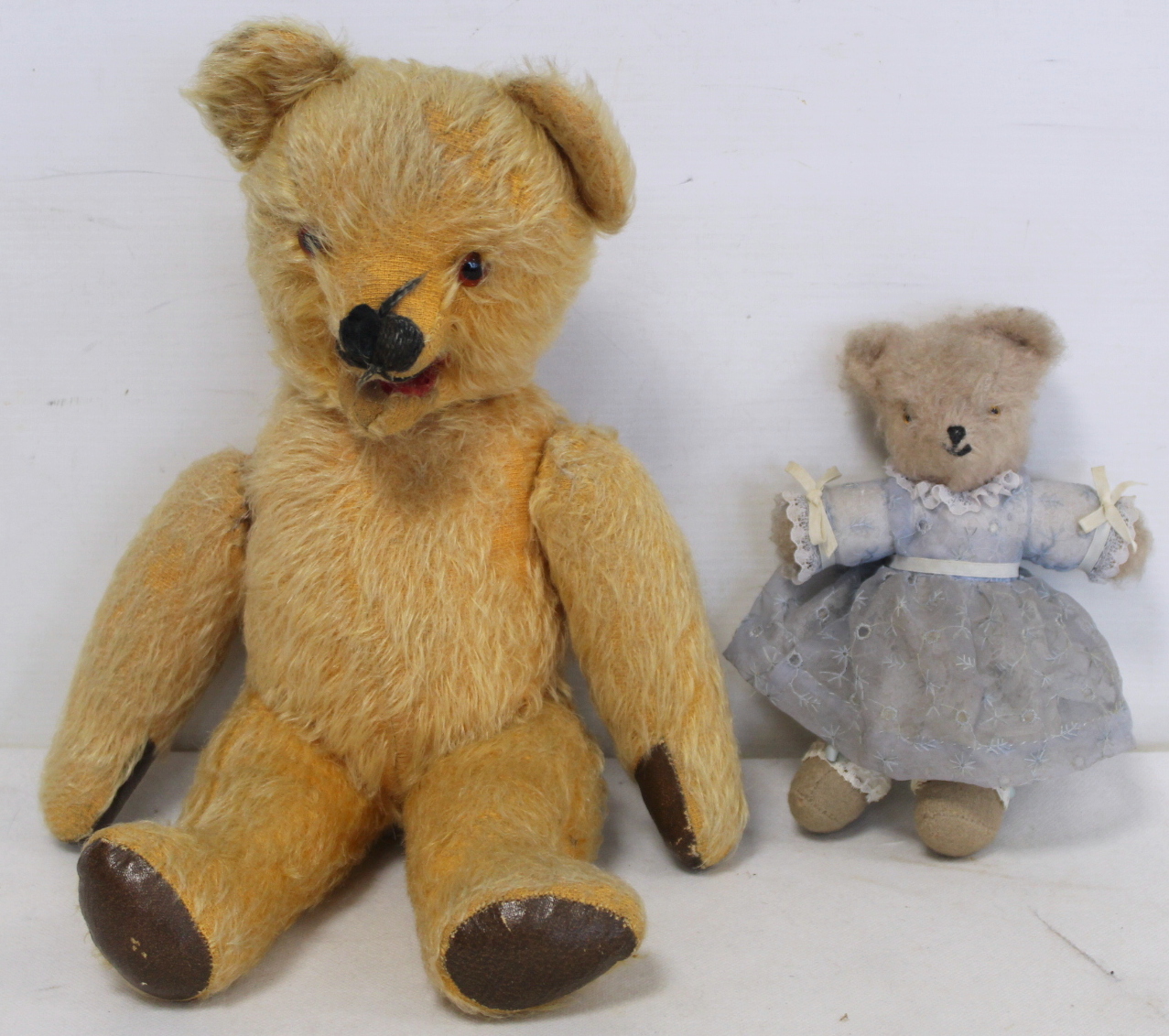 Two early 20th century vintage teddy bears, one miniature in white mohair wearing a blue dress, 19cm