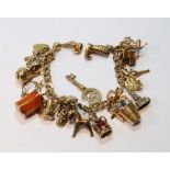 9ct gold diamond-cut curb bracelet with various charms, mostly 9ct gold, 50g.