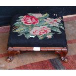 19th century mahogany footstool with a floral decorated needlepoint top, on squat cabriole feet,