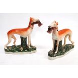 Pair of 19th century Staffordshire pottery greyhounds with prey in their mouths, 15cm high.  (2)