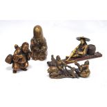 Four oriental cast bronzed figures modelled as a sage holding a scroll, a fisherman on a raft, a
