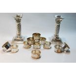 Twelve silver napkin rings, 180g, and a pair of EP dwarf candlesticks with spirally fluted stems.