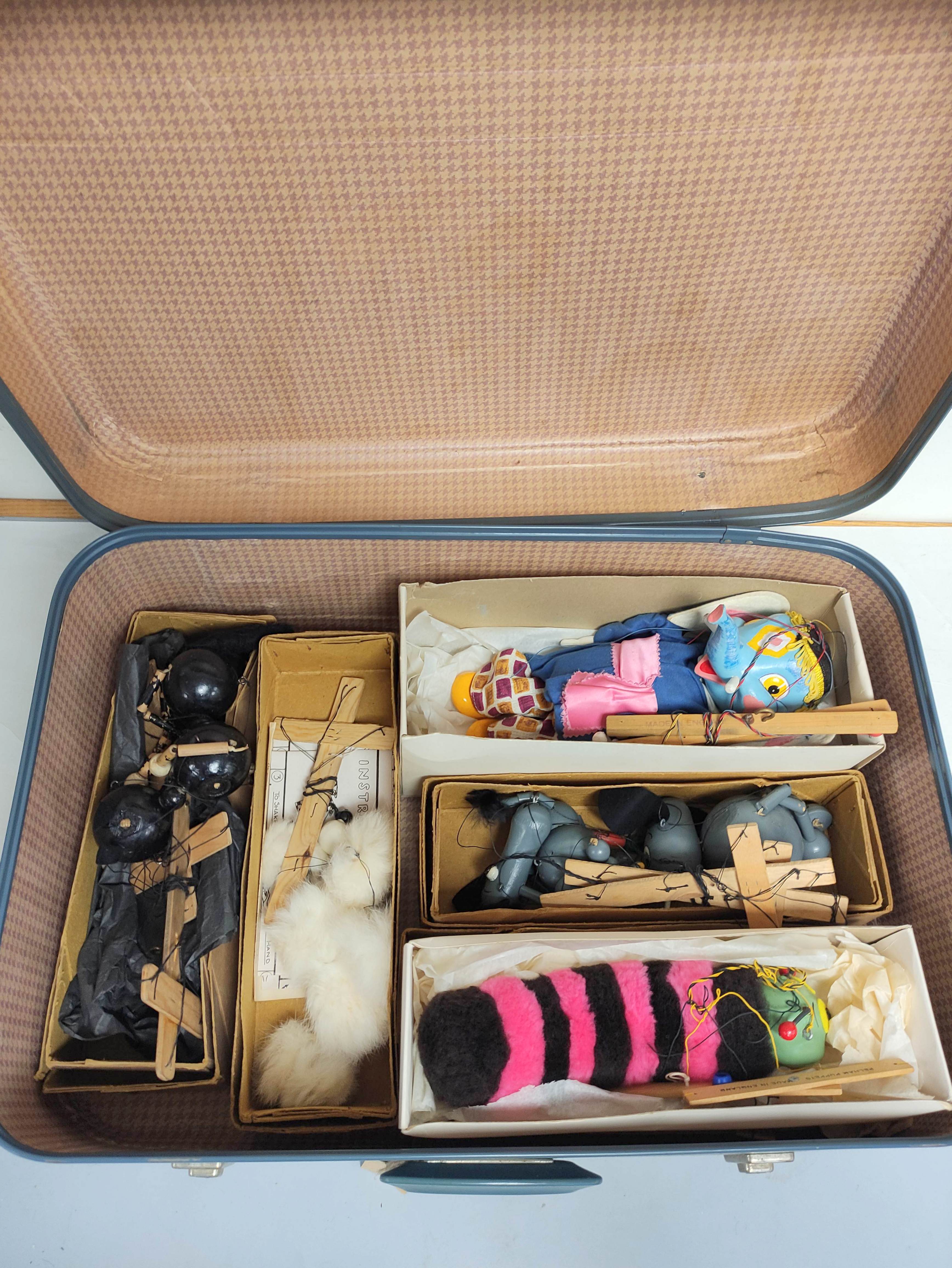 Suitcase containing a quantity of vintage Pelham Puppet animal marionettes to include Elephant