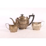 George V silver three-piece tea set with half gadrooned body, the teapot with inscription "To