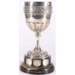 Victorian sterling silver prize cup, on hardwood stand, the cup with chased border of figures,