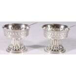 Pair of George V sterling silver salts on fluted bases with non matching silver and EPNS spoons, S.