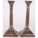 Pair of George V sterling silver Corinthian column candlesticks, each with embossed capitals on