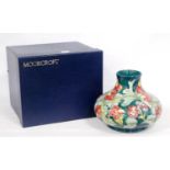 Moorcroft baluster vase with all over tubed lined floral decoration on a green ground, stamped WM to