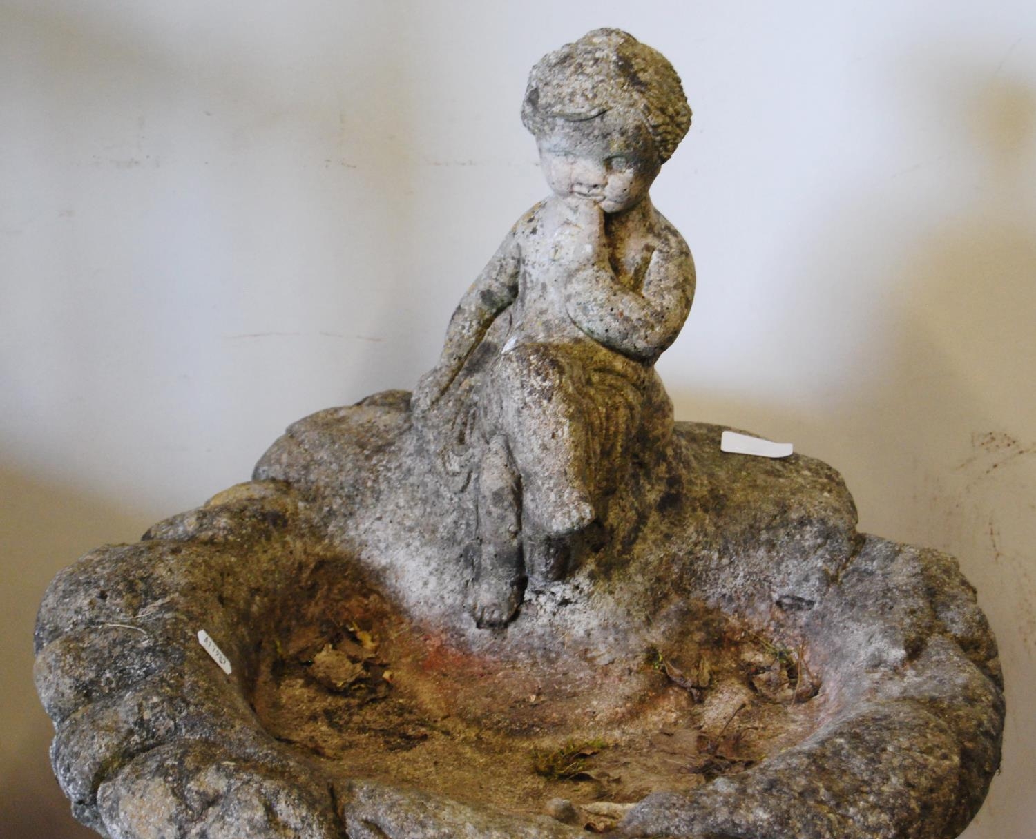 Stone garden bird bath decorated with a putti surmount to the open well, the cylindrical column with - Image 3 of 4