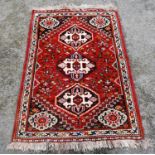 Persian hand-knotted rug, decorated with three geometric medallions to the centre, with a similar