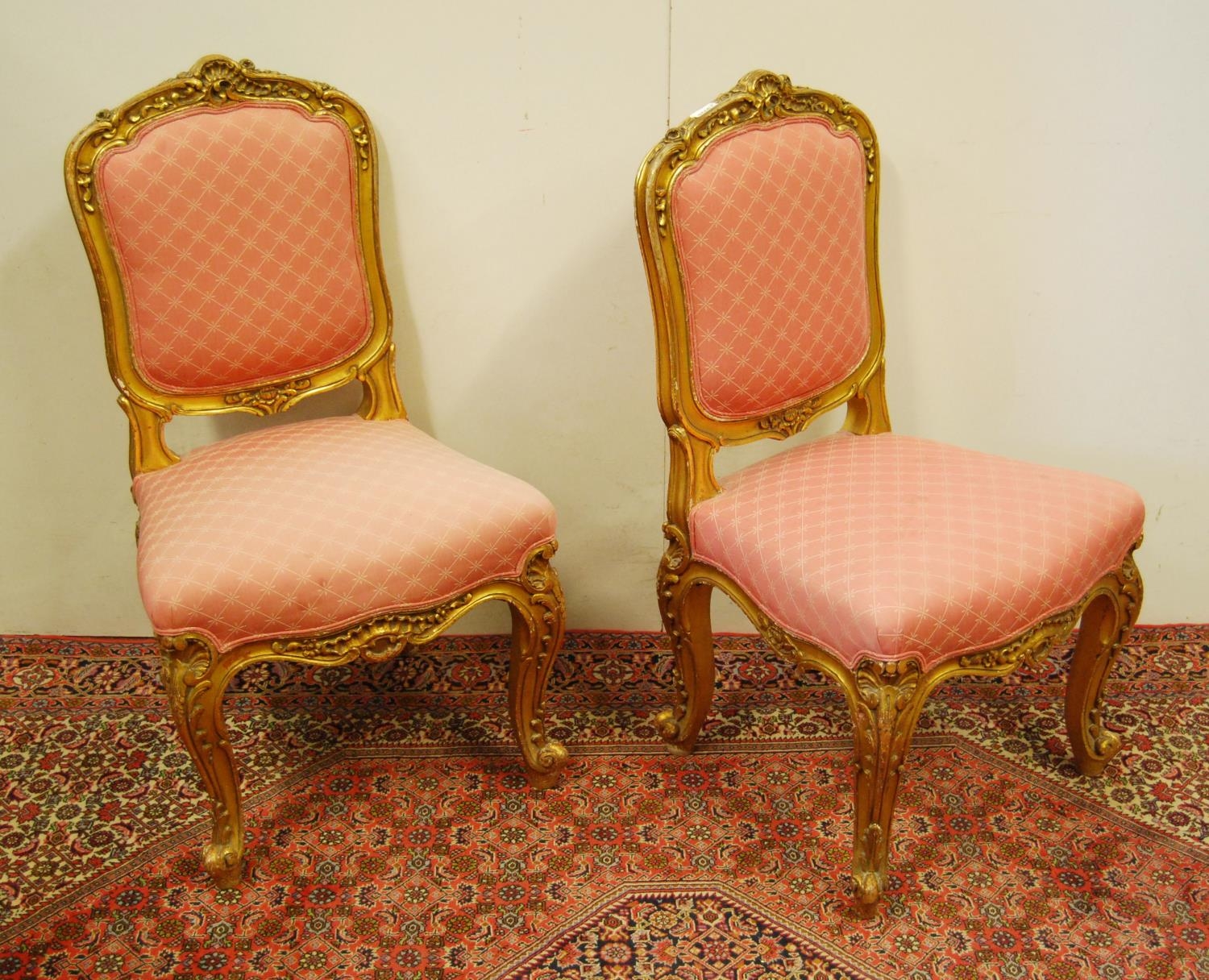 Pair of Louis XV style giltwood parlour chairs decorated with moulded roses, floral panels and