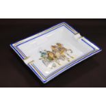 Hermès porcelain ashtray depicting a coaching scene, with painted blue and gold border, signed