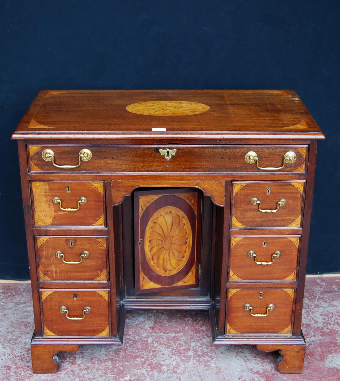 George III style inlaid mahogany kneehole desk, the long drawer above a cupboard door