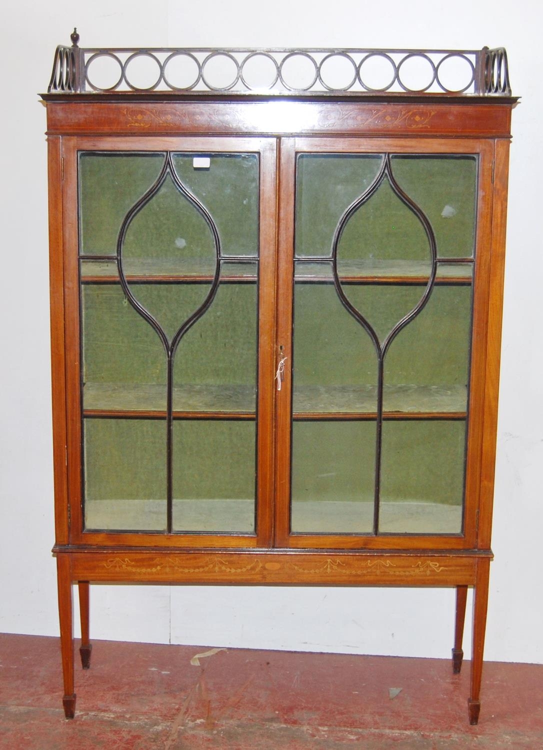 Edwardian inlaid mahogany display cabinet, with a concentric pierced pediment top above an inlaid