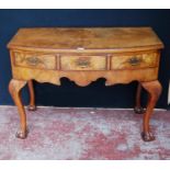 Queen Anne-style walnut desk, with three short drawers above a shaped apron, on cabriole legs with