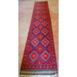 Persian runner decorated all over with geometric diamond lozenge medallions on a red and blue