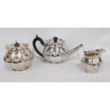 Silver three-piece tea set of lobed globular form, with engraved bands and waved capes, by S