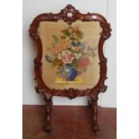 Victorian mahogany fire screen, with a needlepoint panel to the centre depicting flowers in a