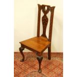 Early 20th century carved oak hall chair, the shaped top above a fiddle-shaped back rest carved with