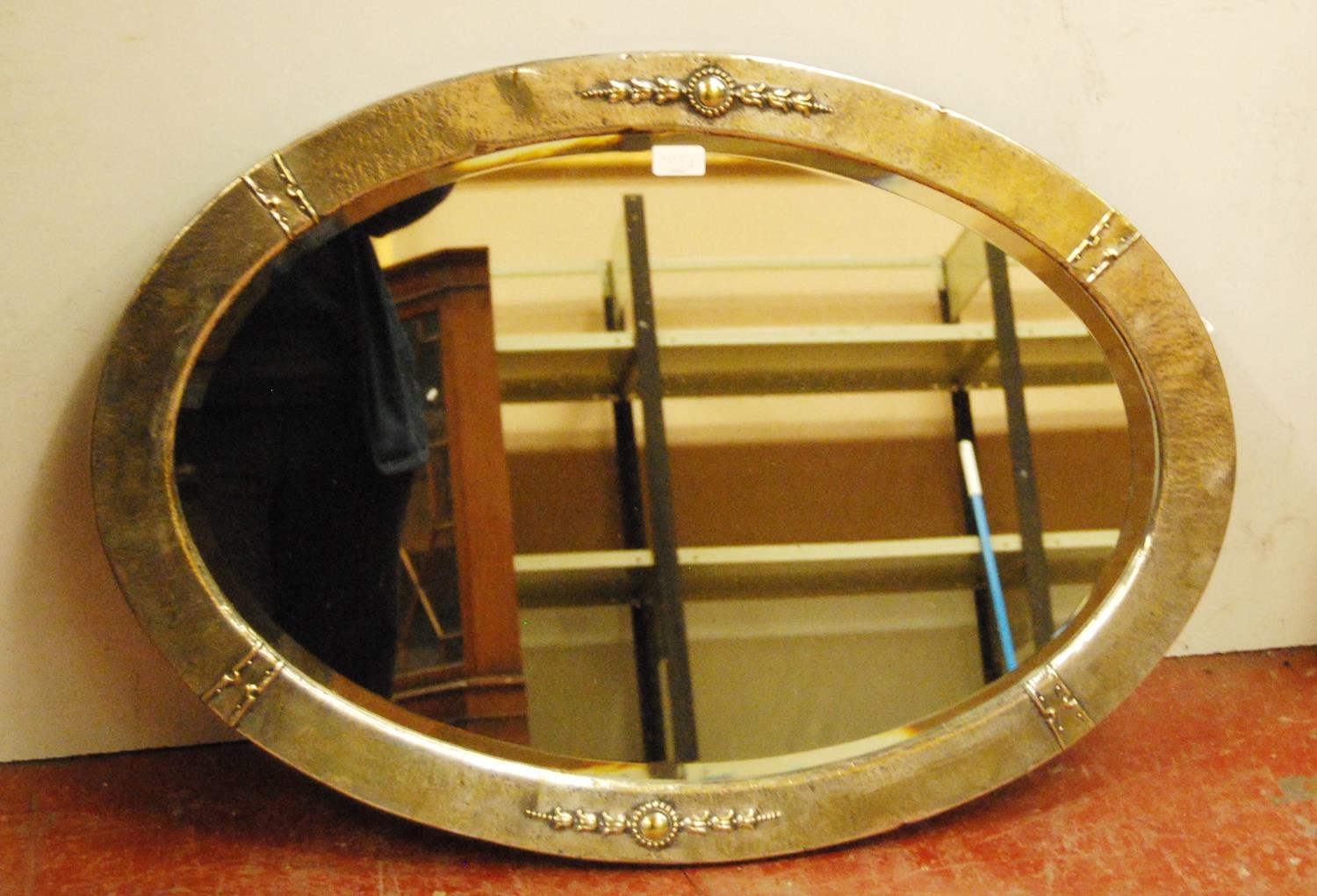 Early 20th century Arts & Crafts-style hammered white metal oval mirror, decorated with floral