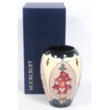 Moorcroft vase with floral tube lined decoration on a cream and blue ground, stamped WM to the