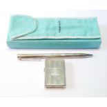 Zippo-style lighter in silver case for Tiffany & Co., and a silver ballpoint pen, for the same.