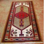 Persian rug decorated with all over geometric motifs on a red, beige, blue and cream ground, 217cm x