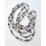 Long pearl necklace, blue, black and other hues.