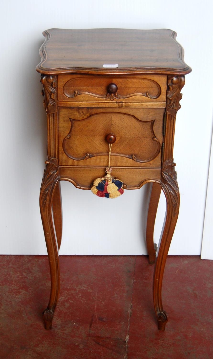 French-style walnut pot cupboard, the shaped top above a short drawer and cupboard door, on acanthus