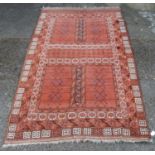 Turkish hand-knotted rug with all over geometric motifs and guls on a rust ground, 205cm x 120cm.