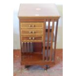 Edwardian inlaid mahogany revolving bookcase, with open shelving and three short drawers to the