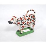 19th century pottery cow creamer, with replacement stopper, fixed to a painted plinth