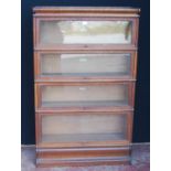 Globe Wernicke oak stacking bookcase, with four glazed sections, on base, with label to each section