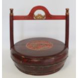 Chinese circular wooden wedding basket decorated in red lacquer and gilt with central circular panel